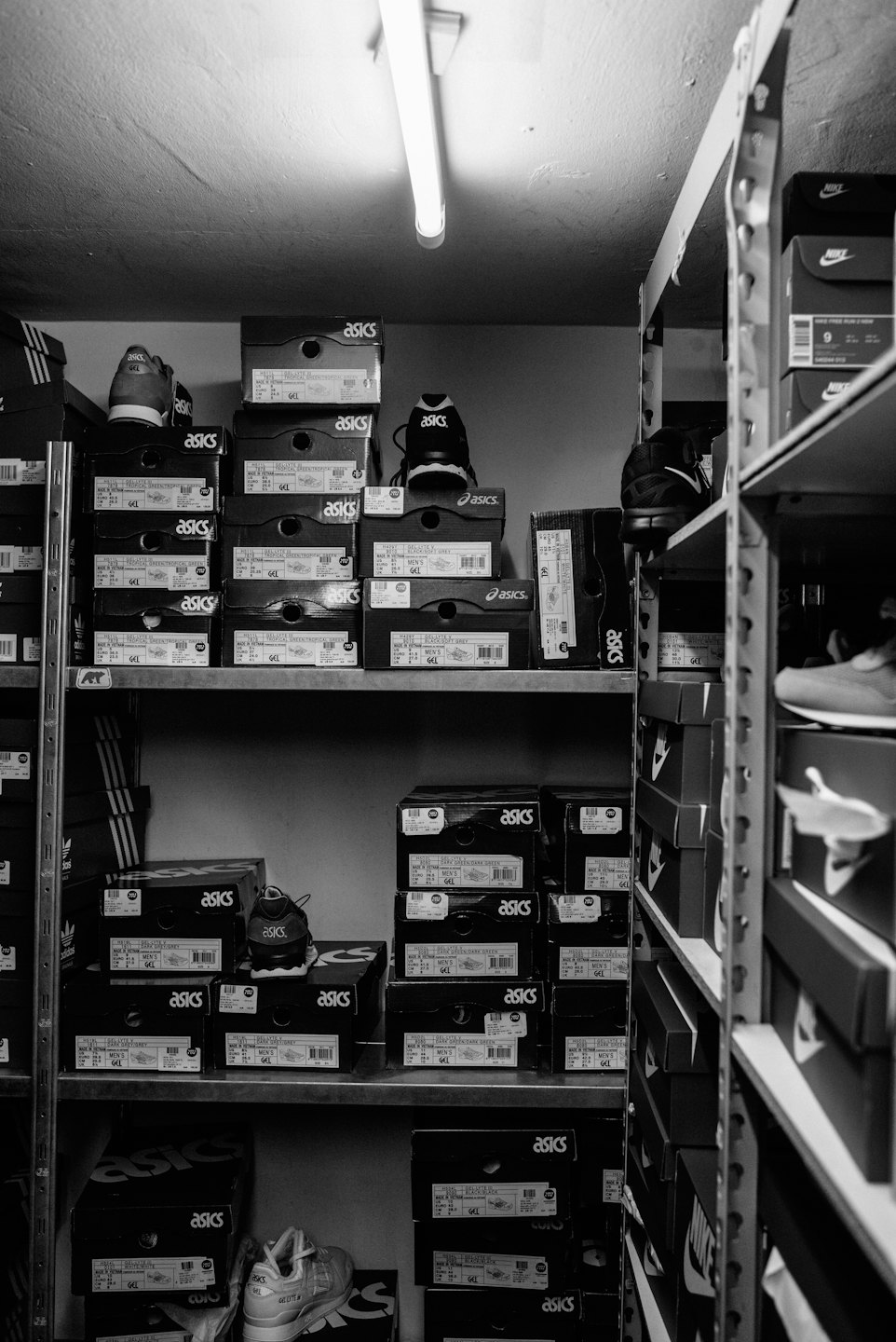 Scatole di scarpe impilate su scaffali in un magazzino.