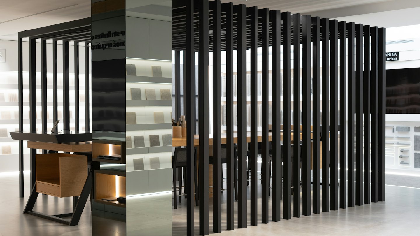 Moderno showroom d'ufficio con scrivanie in legno e scaffali con campioni di materiali.