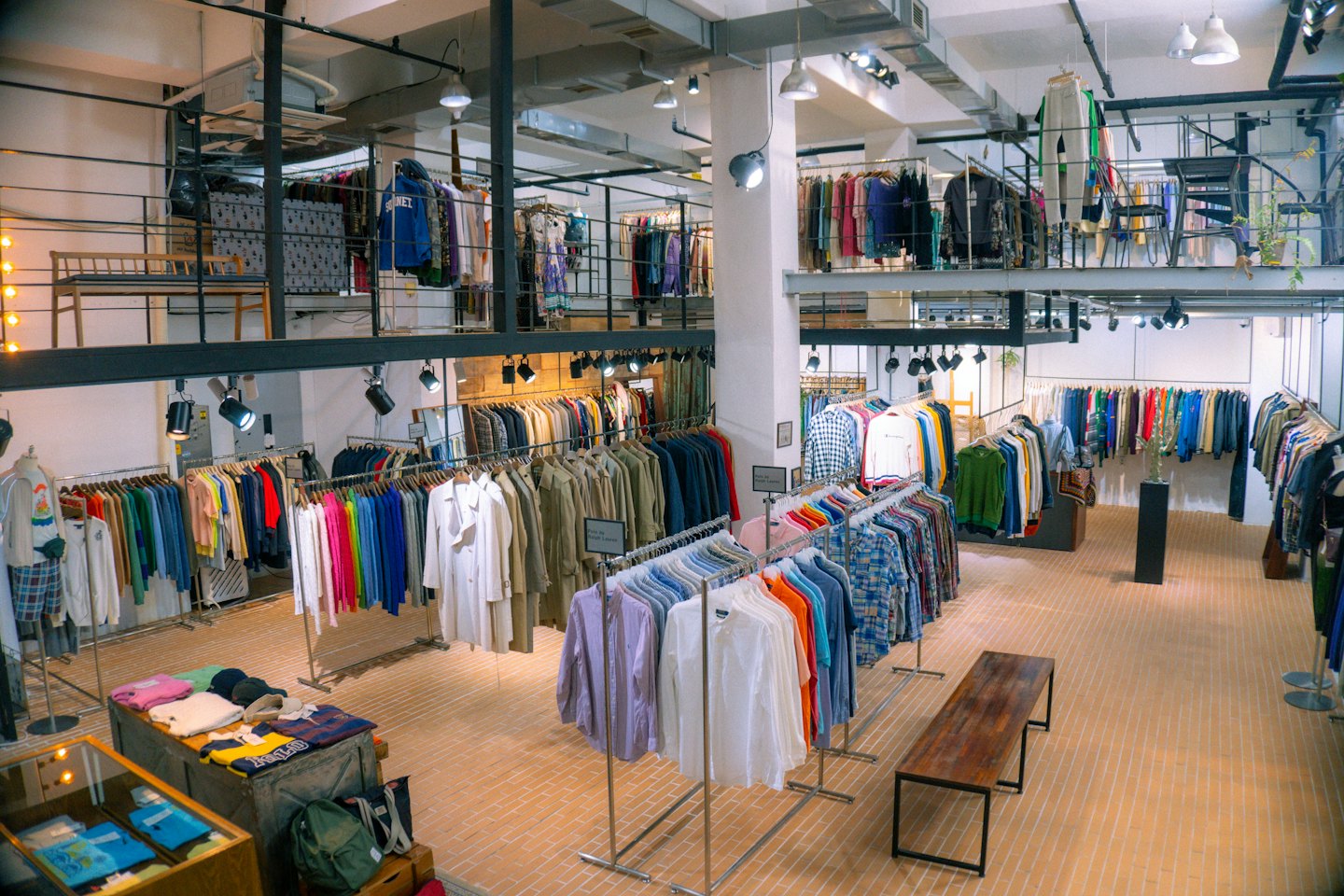 Interno di un moderno negozio di abbigliamento con scaffali di capi colorati.